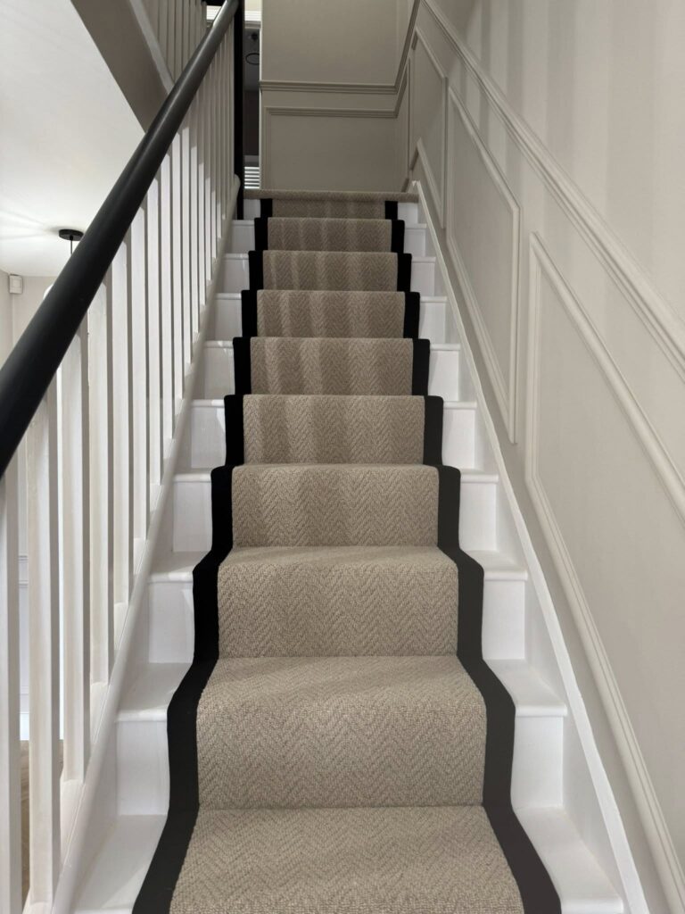 Cream wool herringbone stair runner with black border, fitted by Cuttin Edge Carpets in a Halifax period property