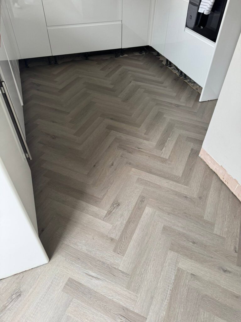 Grey herringbone luxury vinyl tile flooring fitted in a modern kitchen by Cuttin Edge Carpets Halifax