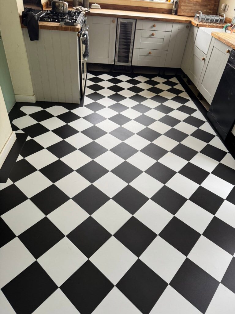 Black and white checkerboard vinyl floor fitted in a Halifax kitchen by Cuttin Edge Carpets